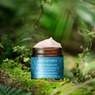 Antipodes Baptise Hyaluronic Gel, 60ml jar, on mossy forest floor.