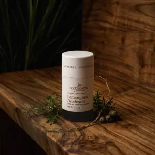 Eco by Sonya lemongrass deodorant on wooden surface with greenery.