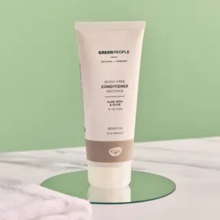 Green People scent-free conditioner tube on a green surface.