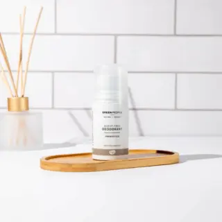Scent-free deodorant on wooden tray, white tiled background.