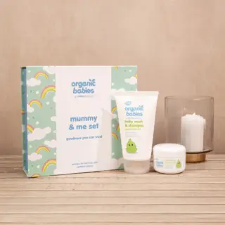 Organic Babies Mummy & Me set with baby wash, cream, and candle on wooden surface.