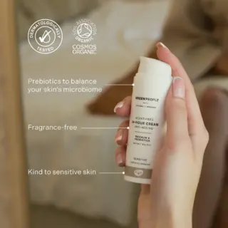 Hand holding Green People 24-hour cream. Text highlights prebiotics, fragrance-free, sensitive skin.