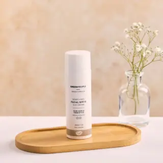 Facial SPF15 sun cream on wooden tray, vase with flowers in background.