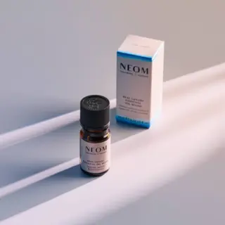 NEOM essential oil bottle and box on a light surface.