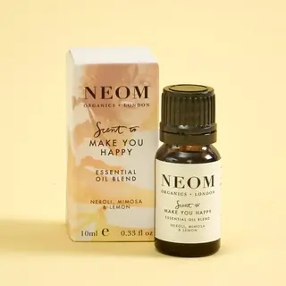 Neom Organics essential oil blend, neroli, mimosa, lemon, 10ml bottle and box on yellow background.