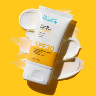 Sunscreen tube with SPF 30 on a yellow background, cream smeared behind.
