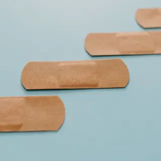 Adhesive plasters arranged diagonally on a blue background.
