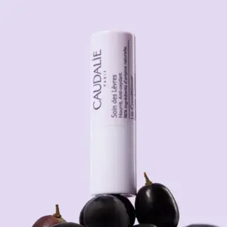 Lip conditioner tube with grapes, text in French and English.
