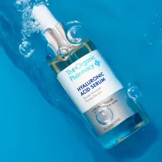 Hyaluronic Acid Serum bottle submerged in water with bubbles.