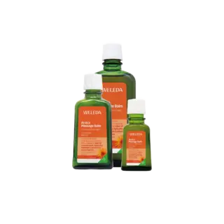 Three bottles of Weleda Arnica Massage Balm with orange labels.