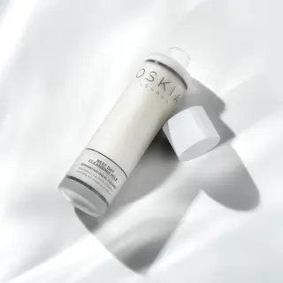 Oskia Rest Day Cleansing Milk bottle on white surface, cap off.