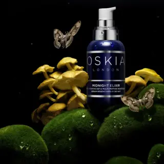 Oskia London Midnight Elixir bottle with mushrooms, moss, and moths in a dark setting.