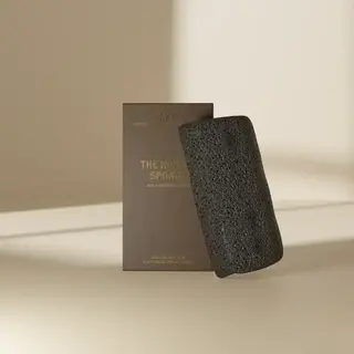 Black konjac sponge with brown packaging on a beige background.
