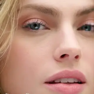 Close-up of a woman's face with pink eyeshadow and lipstick. Text: "Desert Rose".