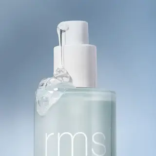 Clear bottle with "rms" text, white pump, and gel oozing out, set against a blue background.
