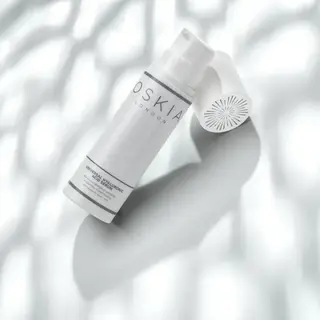 White bottle of Oskia London Hyaluronic Acid Serum on a textured white background.