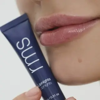 Close-up of lips with a blue tube labelled "rms Liplights".