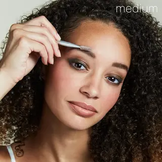 Person using eyebrow brush, text "medium" in corner.