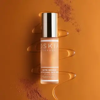 Oskia London Nutri-Bronze serum bottle on bronze background with liquid and powder accents.