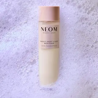 NEOM bath foam bottle on bubbly surface. Text: Perfect Night's Sleep, Lavender, Chamomile, Patchouli.