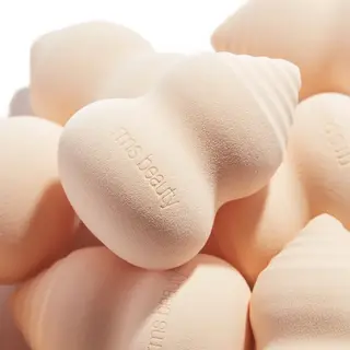 Peach-coloured makeup sponges with "rms beauty" embossed.