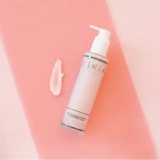 Oskia Renaissance Body Treatment Milk on pink surface with cream smear.