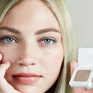 Person holding a compact with light brown eyeshadow. Text: "Light".
