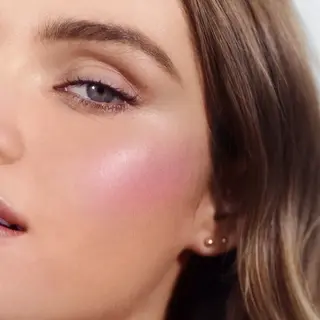 Close-up of a woman's face with pink blush. Text: "French Rosé".