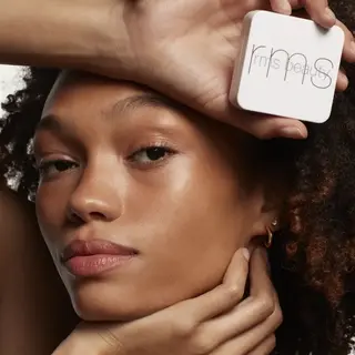 Person holding RMS Beauty compact, text "TAN LINES" in corner.