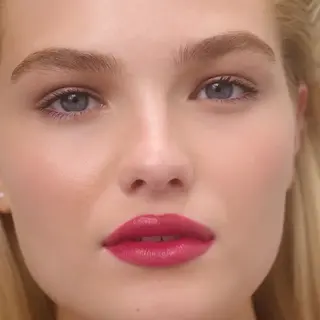 Close-up of a person with pink lipstick and blue eyes. Text: "LINDA" in the corner.