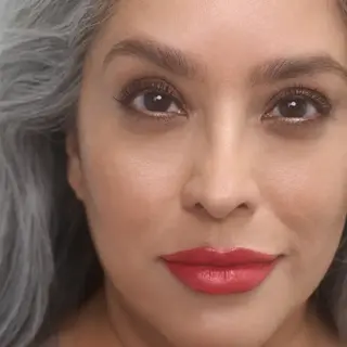 Woman with grey hair and red lipstick, text "AUDREY" in corner.