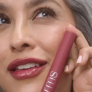 Woman holding a pink rms beauty product near her face. Text: "ANGELA".