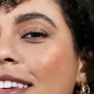 Close-up of a woman's face with peach blush on cheek. Text: "MAI TAI".