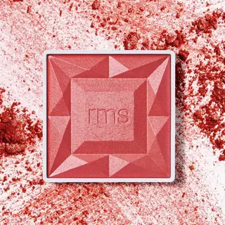 Red blush compact with "rms" logo, surrounded by scattered blush powder.