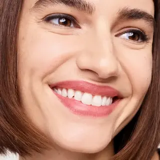 Smiling person with short brown hair and visible teeth.