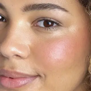 Close-up of a person's face with glowing skin and pink blush. Text: "SANGRIA".