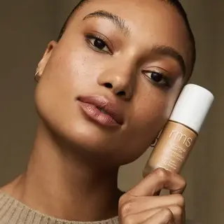 Person holding rms beauty foundation bottle labelled "Honey".