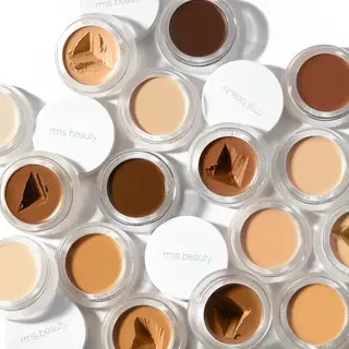 Assorted RMS Beauty concealer pots in various skin tones.
