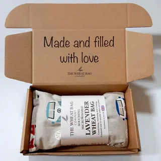 Open box with a lavender wheat bag inside. Text: "Made and filled with love".