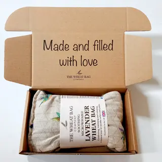 Open box with a lavender wheat bag inside. Text: "Made and filled with love".