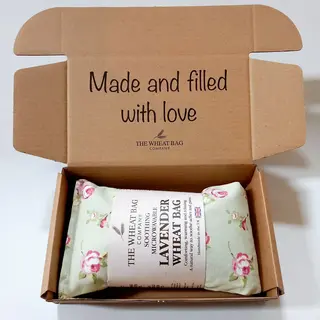 Open box with lavender wheat bag, floral pattern, text: "Made and filled with love".