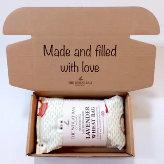Open box with a lavender wheat bag inside. Text: "Made and filled with love".