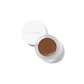 Open jar of brown cream makeup with "rms beauty" on the lid.