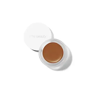 Open jar of brown cream makeup with "rms beauty" on the lid.