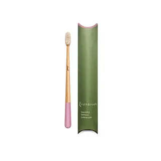 Bamboo toothbrush with pink handle, green packaging labelled "truthbrush".