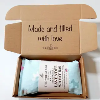 Open box with lavender wheat bag and text "Made and filled with love".