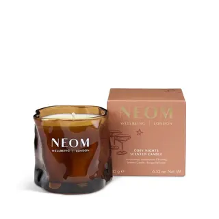 Brown glass candle with "NEOM Wellbeing London" text, next to a matching box labelled "Cosy Nights".