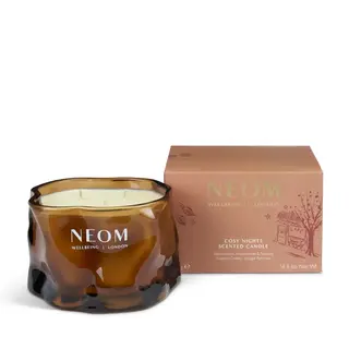 Brown glass candle jar with "NEOM Wellbeing London" text, next to a matching box.