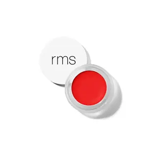 Red lip balm in a clear pot with a white lid displaying "rms".