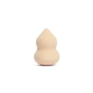 Beige makeup sponge with "rms beauty" embossed, shaped like a gourd.